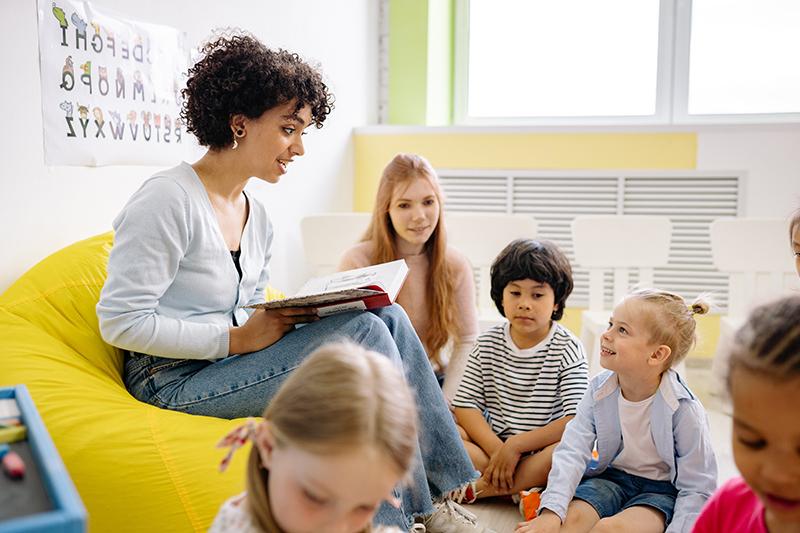 Instrutor reading book and discussing story with elementary students