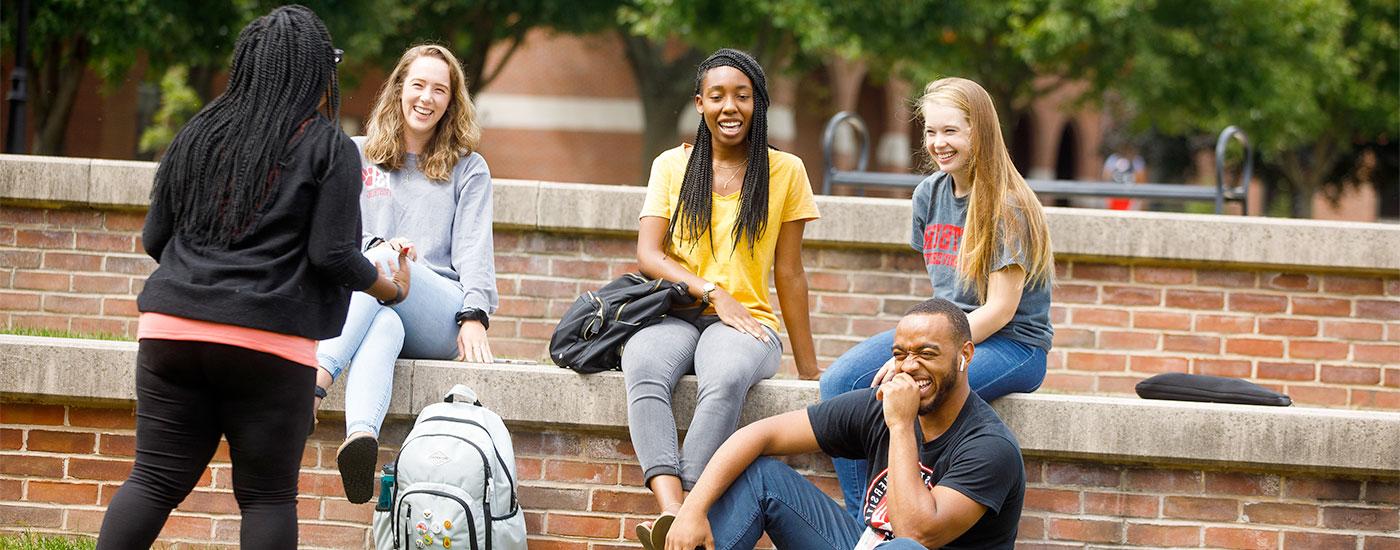 5 Frostburg State students outside laughing at something one of the others said