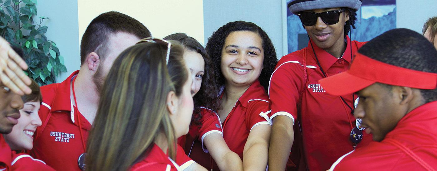 Admissions student ambassadors put their hands in together in a circle before an event