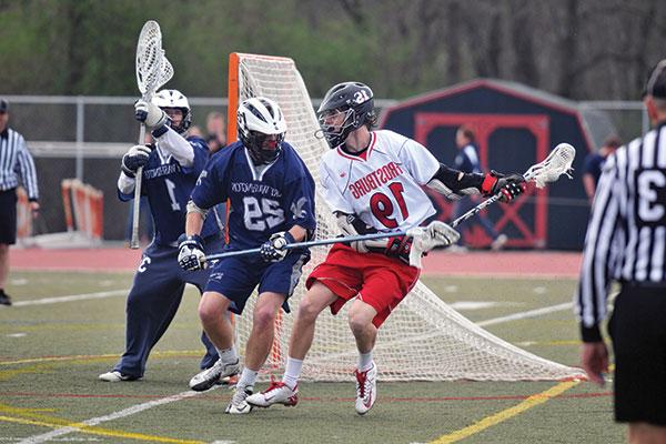 An attackman larosse player cradles the ball away from a long pole defenseman during a game against Mary Washington University